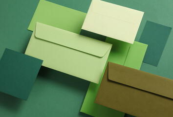 Wall Mural - Set of floating green tones envelopes and cards on green  background. Invitations, corporate identification