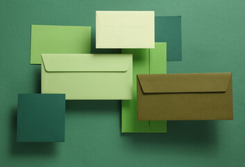 Wall Mural - Set of floating green tones envelopes and cards on green  background. Invitations, corporate identification