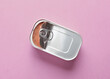Open tin can with food on pink background. Top view