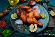 Baked chicken or turkey with rosemary, lemon and spices on a black stone plate. Traditional festive dish.