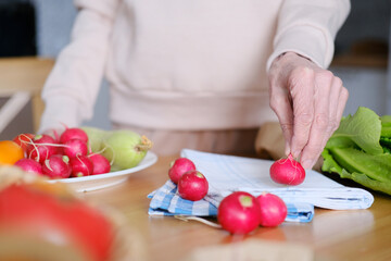 Elderly woman holding a radish in her hand