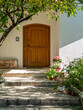 A contemporary design house entrance with an arched wooden door by a green garden. Travel to Athens, Greece.