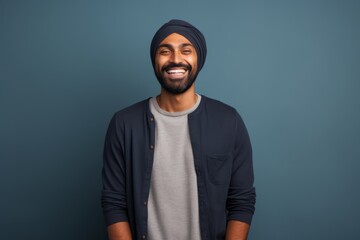 Wall Mural - Portrait of a happy indian man in his 30s sporting a trendy beanie isolated in minimalist or empty room background