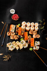 Sticker - Diverse Makizushi Rolls Set on a Black Slate Plate, Elegant Japanese Cuisine Presentation