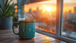 A steaming coffee mug by a window at sunrise.