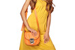 Portrait of Fashion Young Woman in Yellow Dress. Female Model in Stylish Spring Summer Outfit. Girl Posing on a transparent Background. Blonde Lady with Orange Handbag