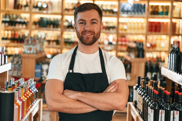 Wall Mural - With arms crossed. Wine shop owner in white shirt and black apron