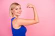 Profile photo of pretty young woman show flex biceps empty space wear blue top isolated on pink color background