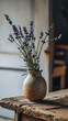 A bunch of lavender flower in a textured rustic ceramic vase on a wooden table in old style kitchen. Vintage country style home interior