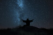 Beneath a starry sky, Jesus lies prostrate on a hilltop, arms outstretched towards the heavens, his figure silhouetted against the vast expanse of the cosmos, seeking divine guidan