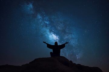 Wall Mural - Beneath a starry sky, Jesus lies prostrate on a hilltop, arms outstretched towards the heavens, his figure silhouetted against the vast expanse of the cosmos, seeking divine guidan