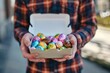 Man holding a box of chocolate eggs in hands with plaid shirt on, Easter holiday concept