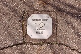 Fototapeta Niebo - A close view of the distance marker sign on the path.