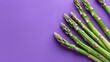 Fresh green asparagus on a purple background. Delicious and healthy vegetables. Vegetarianism.