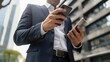 © buraratn - businessman checking financial data on his smartphone, staying productive outside the office