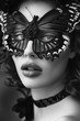 Mysterious woman wearing a butterfly mask posing in front of a black and white background