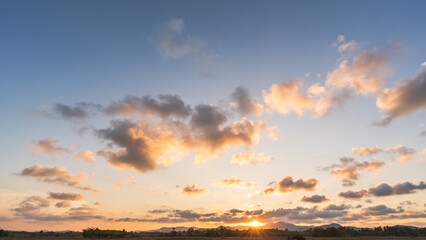 Wall Mural - sunset sky over hill countryside in the evening, horizon sunny summer sky landscape with orange sunl