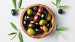 Top view of delicious black, green and red olives with leaves in a wooden bowl, isolated on white background