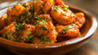 Bangladeshi shrimp curry served with fresh herbs on a terracotta platter
