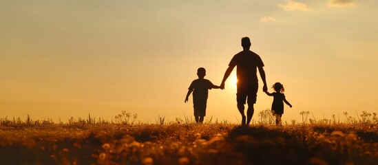 Silhouette of loving father walking side by side with his son holding hands in sunset wild field with large copy space, concept of Father's Day, greeting card, backgrounds.