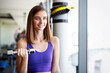 Fitness woman. Fit fitness girl smiling happy lifting weights looking strength training muscles.