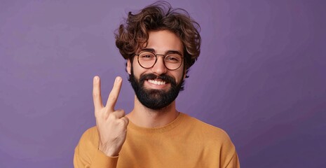 Wall Mural - Portrait of happy young man with wavy hair and beard showing two fingers