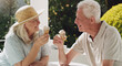 © peopleimages.com - Senior, couple or ice cream in garden with talk for retirement, planning vacation for anniversary. Husband, wife or old on patio for conversation with gelato, sunshine in summer with partner in home