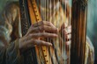 Close-up of elegant hands playing a golden harp with intricate details and warm tones.