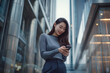 © 수동 김 - A young asian woman stands outside an office building, smiling and looking at her phone in hand