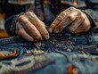 A close up of a tailor's hands sewing a button on a pair of jeans.