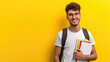 © Luxetify - Male student wearing a white shirt and glasses smiling at the camera while holding a book. yellow background