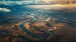 A dramatic aerial view of a meandering river snaking through a vast landscape, showcasing the grandeur and beauty of nature's waterways.