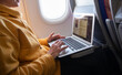 woman working on a laptop during flight