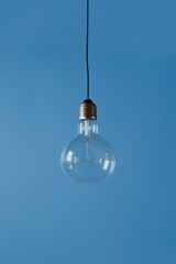 Aufkleber - Light bulb hanging from a wire, suitable for concepts of creativity and innovation