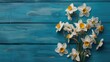 Beautiful white and yellow flowers arranged on a blue wooden surface, perfect for various design projects