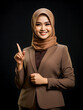 Beautiful business woman with hijab pointing finger portrait on dark background