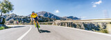 Fototapeta Paryż - Mature Adult on a racing bike climbing the hill at mediterranean sea landscape coastal mountain road - mallorca mountains