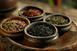 assorted tea leaves collection in wooden bowls on dark table