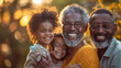 copy space, stockphoto, Happy multigenerational family of four smiling at the camera, with father and mother holding young children aged around five or six with curly hair. The grandpa is older than d