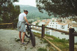 © Taras Grebinets - Young male traveler standing beside bicycle and happy for view of the nature and city in mountains on background