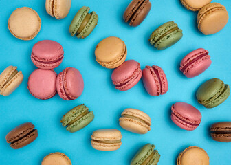 Wall Mural - Multicolored macarons on a blue background, top view, dessert