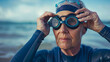 Portrait of a senior woman putting on swimming goggles at the beach. Outdoor wild swimming