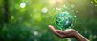 Symbols for sustainable development and a green blurred bokeh background with a hand holding the Earth