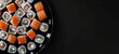 Sushi and rolls on a plate. View from above. place for text. On a black background. generative ai