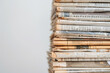 uplifting close-up of well-loved old newspapers stacked neatly, against a white background, symbolizing the enduring legacy and cultural significance of print journalism.