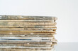 uplifting close-up of well-loved old newspapers stacked neatly, against a white background, symbolizing the enduring legacy and cultural significance of print journalism.