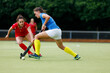Young field hockey player leading the ball in attack.