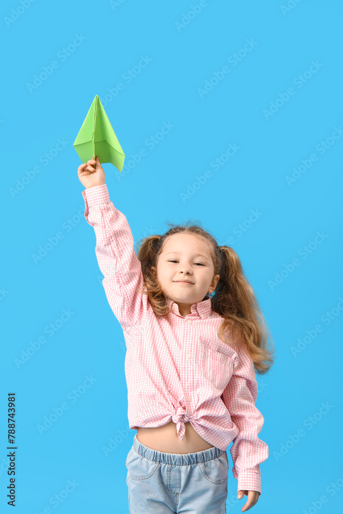 Cute little girl with paper plane on blue background