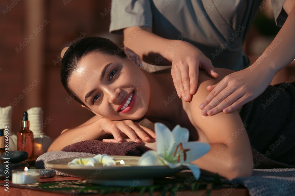 Young woman getting massage in dark spa salon, closeup
