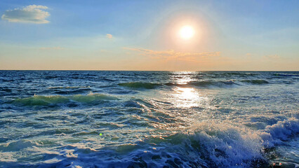 Wall Mural - Colorful sunset with large sun under the sea waves.